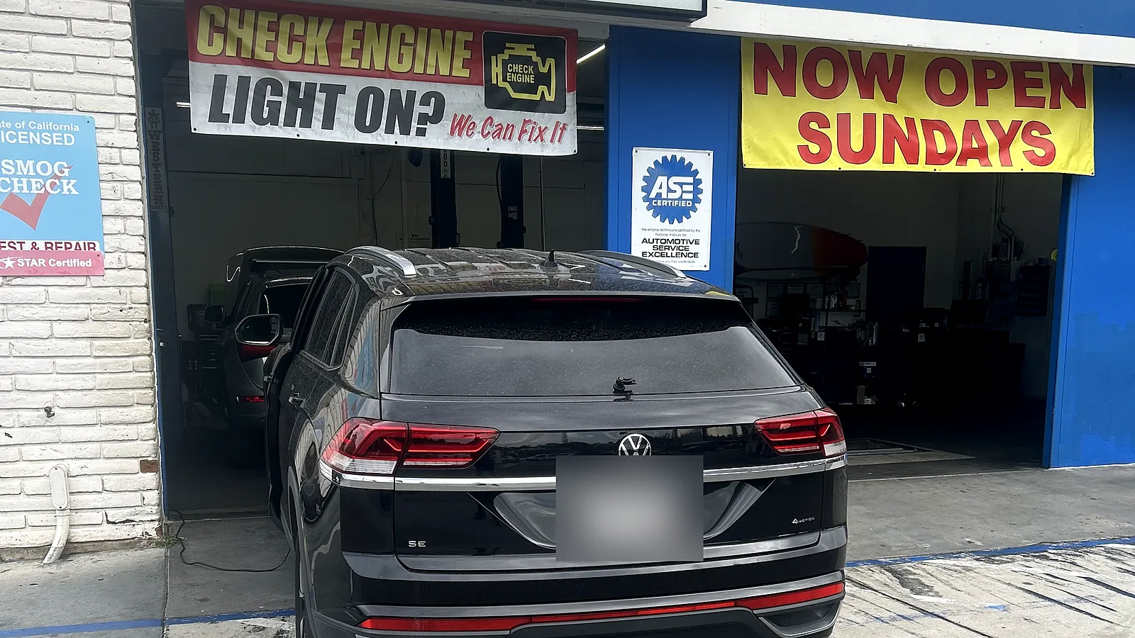Auto repair in Encinitas, CA: Volkswagen SUV pulled up to our service bay under the Smog / Auto Repair sign