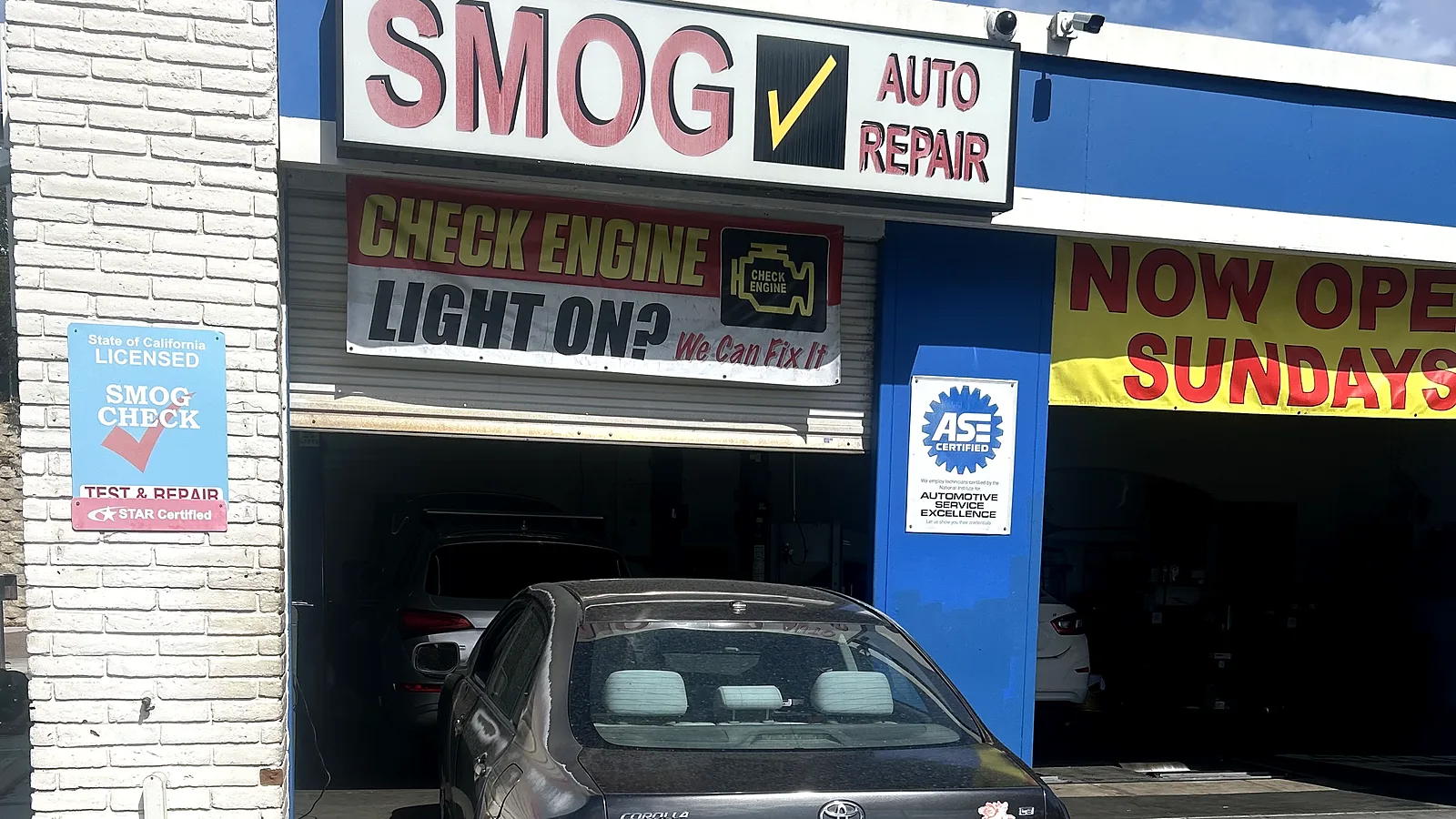 Exhaust and muffler repair in Encinitas, CA: Toyota Corolla at our service bay under the Smog / Auto Repair sign